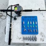 Deep drop fishing gear complete beginner setup on boat deck with electric reel and weights