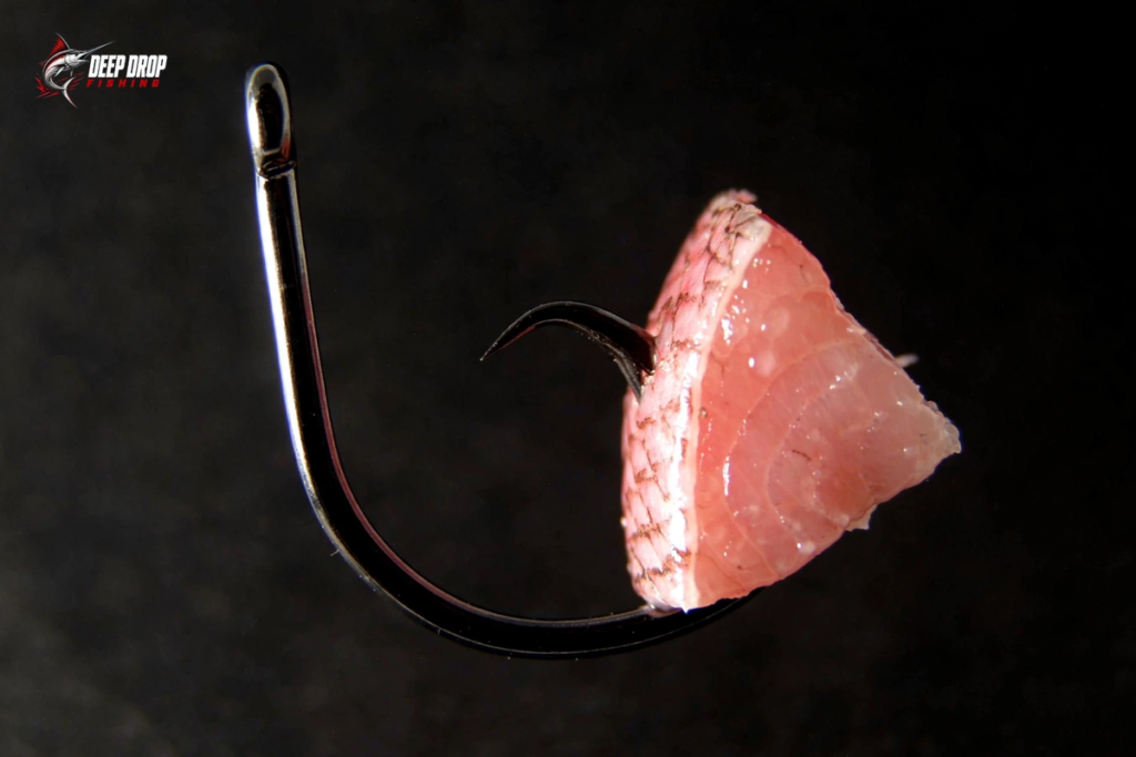 Diagram showing correct hook placement through the firm side of a cut-bait chunk so the bait hangs straight